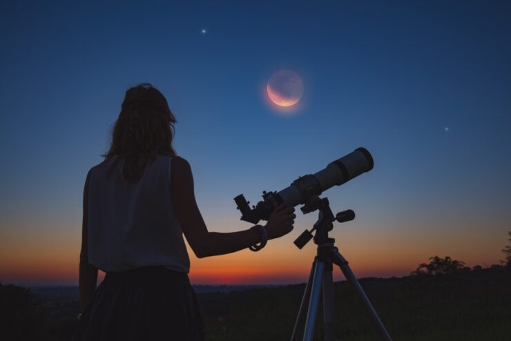 Girl Looking At Lunar Eclipse Through A Telescope